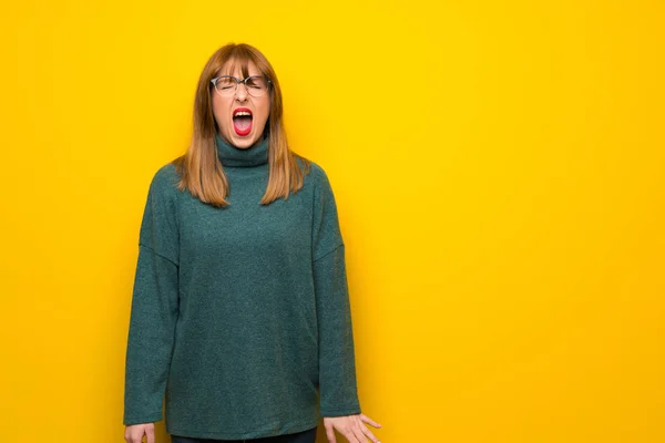 Kobieta Okularach Żółty Ścianę Krzycząc Przodu Otwartymi Ustami — Zdjęcie stockowe