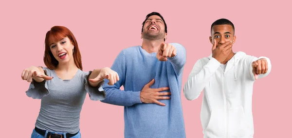 Gruppe von drei Freunden zeigt mit dem Finger auf jemanden und lacht — Stockfoto