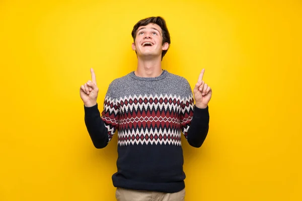 Adolescente Homem Sobre Parede Amarela Surpreendido Apontando Para Cima — Fotografia de Stock