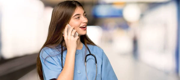 Genç Hemşire Cep Telefonu Ile Bir Görüşme Bir Hastanede Tutmak — Stok fotoğraf