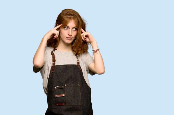 Young Redhead Woman Apron Having Doubts Thinking Blue Background — Stock Photo, Image