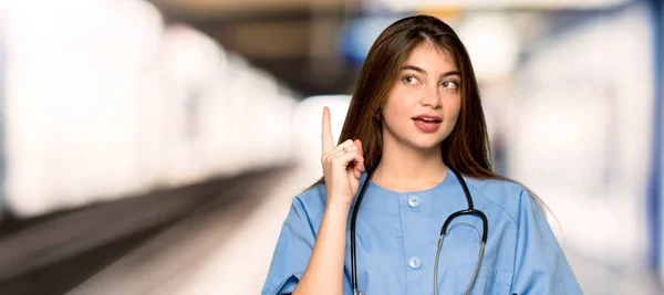 Jovem Enfermeira Pensando Uma Ideia Apontando Dedo Para Cima Hospital — Fotografia de Stock