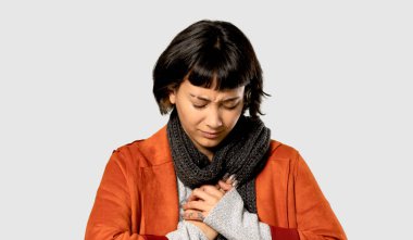 Kısa saçlı kadın ile izole gri arka plan üzerinde kalbinde bir ağrısı olan ceket