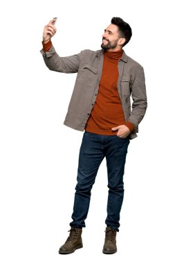 Bir selfie izole beyaz arka plan üzerinde yapma sakallı yakışıklı adam tam uzunlukta atış
