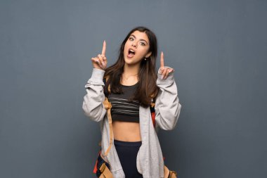 Duvar kadar ve sürpriz işaret üzerinde genç Gezgin kız