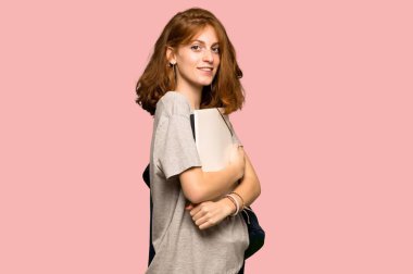 Genç redhead öğrenci kolları çarpı işareti olan ve pembe arka plan üzerinde dört gözle