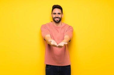 Yakışıklı adam boşaltmak hayali avuç içinde tutan sarı duvarın üzerinden bir reklam eklemek için