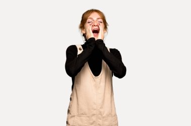 Bağırarak ve gri arka plan üzerinde bir şey ilan genç Kızıl saçlı kadın