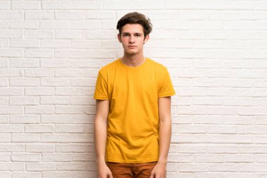 Beyaz tuğla duvara portre genç adam