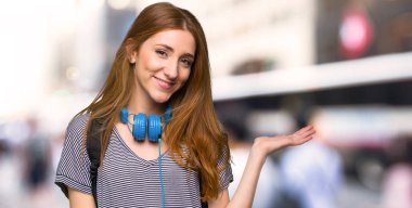 Kızıl saçlı öğrenci kadın görünümlü doğru şehirde gülümseyen iken bir fikir sunmak