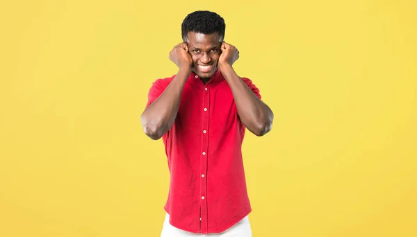 Unga afroamerikanska Manbeläggning båda öronen med händerna. Frustr — Stockfoto