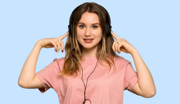 Дівчина Підліток Рожевим Светром Слухає Музику Навушниками Ізольованому Синьому Фоні — стокове фото