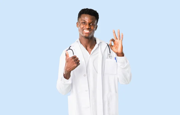 Medico afroamericano che mostra un segno ok con le dita e givi — Foto Stock