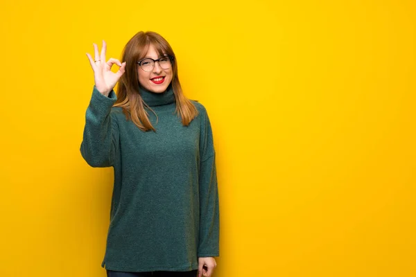 Vrouw Met Bril Gele Muur Tonen Een Teken Met Vingers — Stockfoto