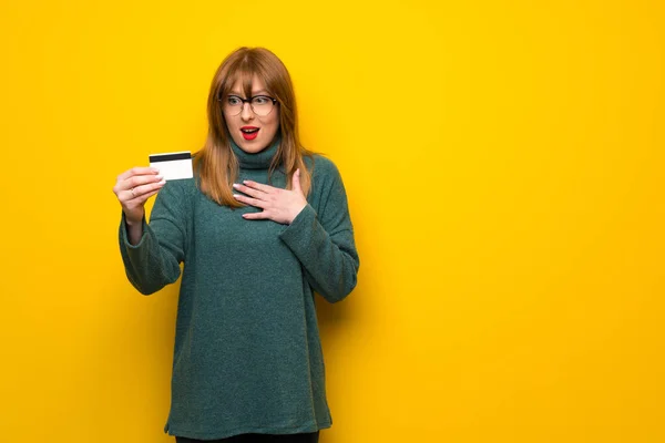 Γυναίκα Γυαλιά Πάνω Από Κίτρινο Τοίχο Κρατώντας Μια Πιστωτική Κάρτα — Φωτογραφία Αρχείου