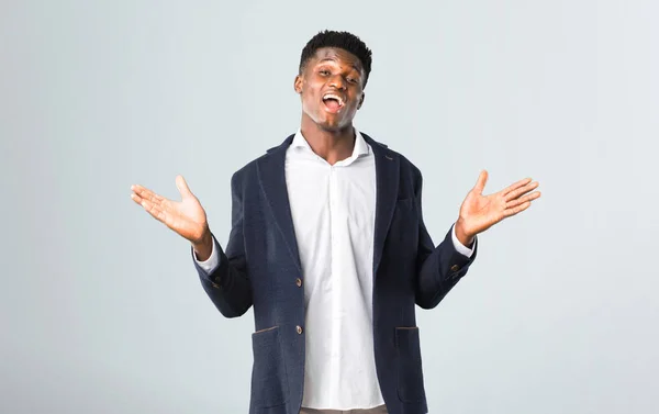 Bonito homem afro-americano vestindo um casaco com surpresa e — Fotografia de Stock