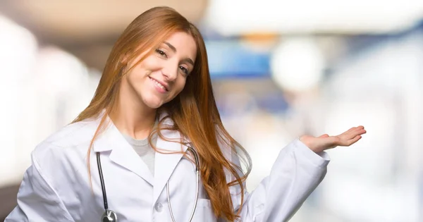 红发医生妇女拿着复制空间想象在手掌插入广告在医院 — 图库照片