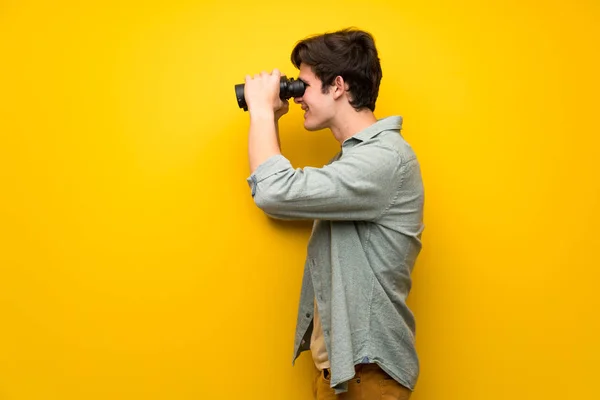 Hombre Adolescente Sobre Pared Amarilla Mirando Distancia Con Prismáticos — Foto de Stock