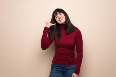 Kırmızı boğazlı kazak telefon jest yapma genç kadınla. Bana arka işareti de