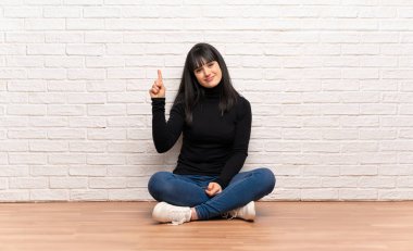 Gösteren ve en iyi iz içinde parmak kaldırma yerde oturan kadın