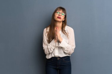 Mavi duvarın üzerinden gözlüklü kadın birlikte palm tutar. Kişi için bir şey sorar