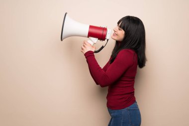 Kırmızı boğazlı bir megafon ile bağırarak genç kadınla lateral pozisyonda bir şey duyurmaktan