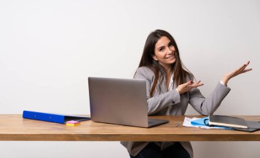 Ofisteki iş kadını, davet edildiği için ellerini yana açıyor.