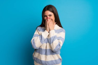 Mavi duvar çok ağız kapsayan süre gülümseyen genç kadın