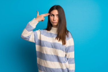 Genç kadın ile intihar jest yaparken sorunlarla mavi duvarın üzerinden