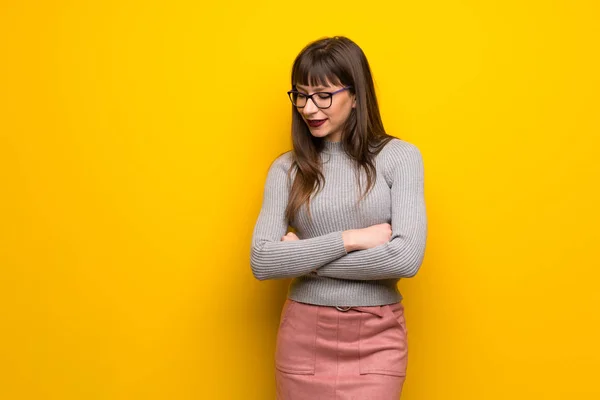 Vrouw Met Bril Gele Muur Kijkt Neer Met Hand Kin — Stockfoto