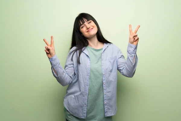 Young Woman Green Wall Smiling Showing Victory Sign Both Hands — Stock Photo, Image