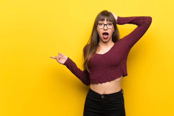 Woman Glasses Yellow Wall Surprised Pointing Finger Side — Stock Photo, Image