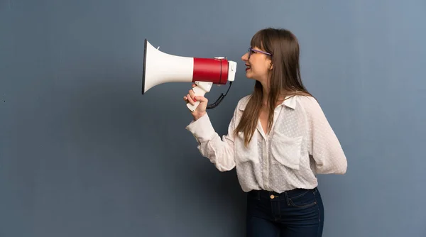 Vrouw Met Bril Blauwe Muur Schreeuwen Door Een Megafoon Kondigen — Stockfoto