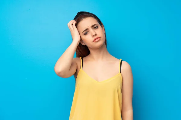 Young redhead woman over blue background with an expression of frustration and not understanding