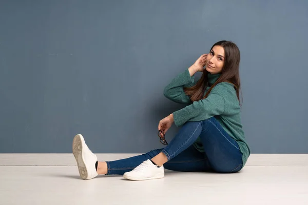 Jonge vrouw zittend op de vloer — Stockfoto