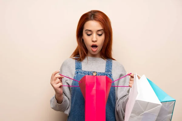 Joven Pelirroja Sobre Fondo Aislado Sorprendido Mientras Sostiene Una Gran — Foto de Stock