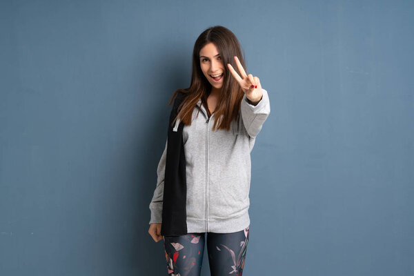 Young sport woman smiling and showing victory sign