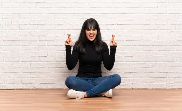 Frau Sitzt Auf Dem Boden Und Drückt Die Daumen — Stockfoto