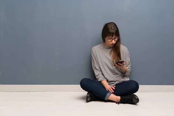 Γυναίκα Γυαλιά Κάθεται Στο Πάτωμα Αποστολή Μηνύματος Κινητό — Φωτογραφία Αρχείου