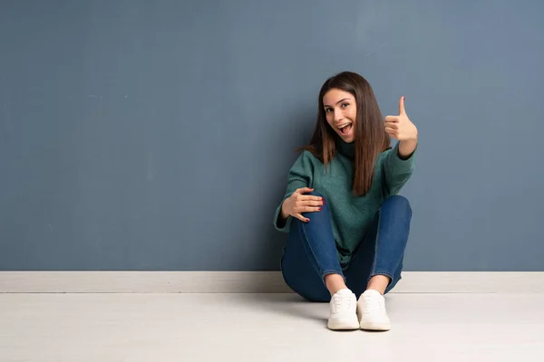 Junge Frau Sitzt Mit Erhobenem Daumen Auf Dem Boden Weil — Stockfoto