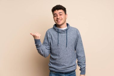 Ürün sunmak için yalıtılmış duvar tarafına işaret eden genç adam