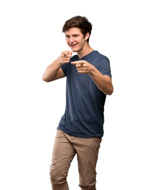 Öne doğru işaret ve izole beyaz arka plan üzerinde gülümseyen genç adam