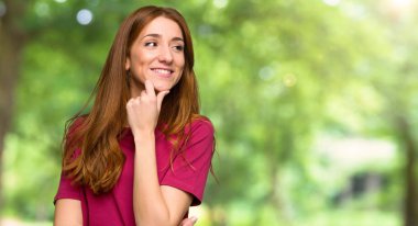 Genç Kızıl saçlı kız tarafına park çene el ile seyir