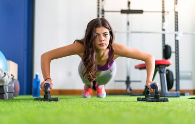 Genç kadın şınav bir spor salonunda spor