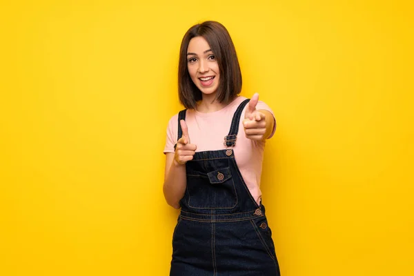 Молода Жінка Над Жовтою Стіною Вказує Пальцем Коли Посміхається — стокове фото