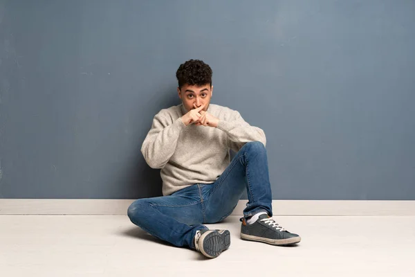 Mladý Muž Sedí Podlaze Ukazuje Znamení Ticha Gesto — Stock fotografie