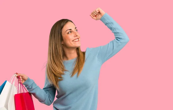 Blonde Frau Mit Blauem Hemd Und Vielen Einkaufstüten Siegerpose Auf — Stockfoto