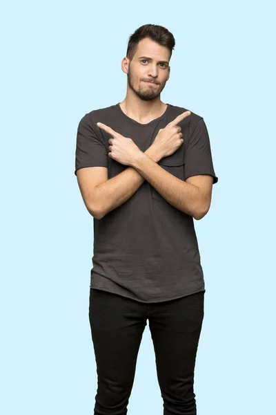 Man Black Shirt Pointing Laterals Having Doubts Blue Background — Stock Photo, Image