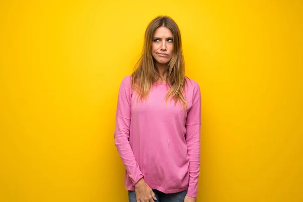 Frau Mit Rosa Pullover Über Gelber Wand Mit Verwirrtem Gesichtsausdruck — Stockfoto