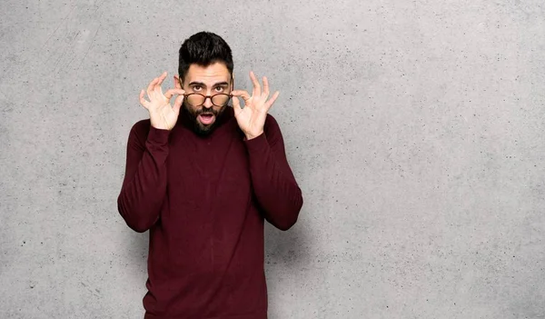 Hombre Guapo Con Gafas Sorprendido Sobre Pared Texturizada —  Fotos de Stock